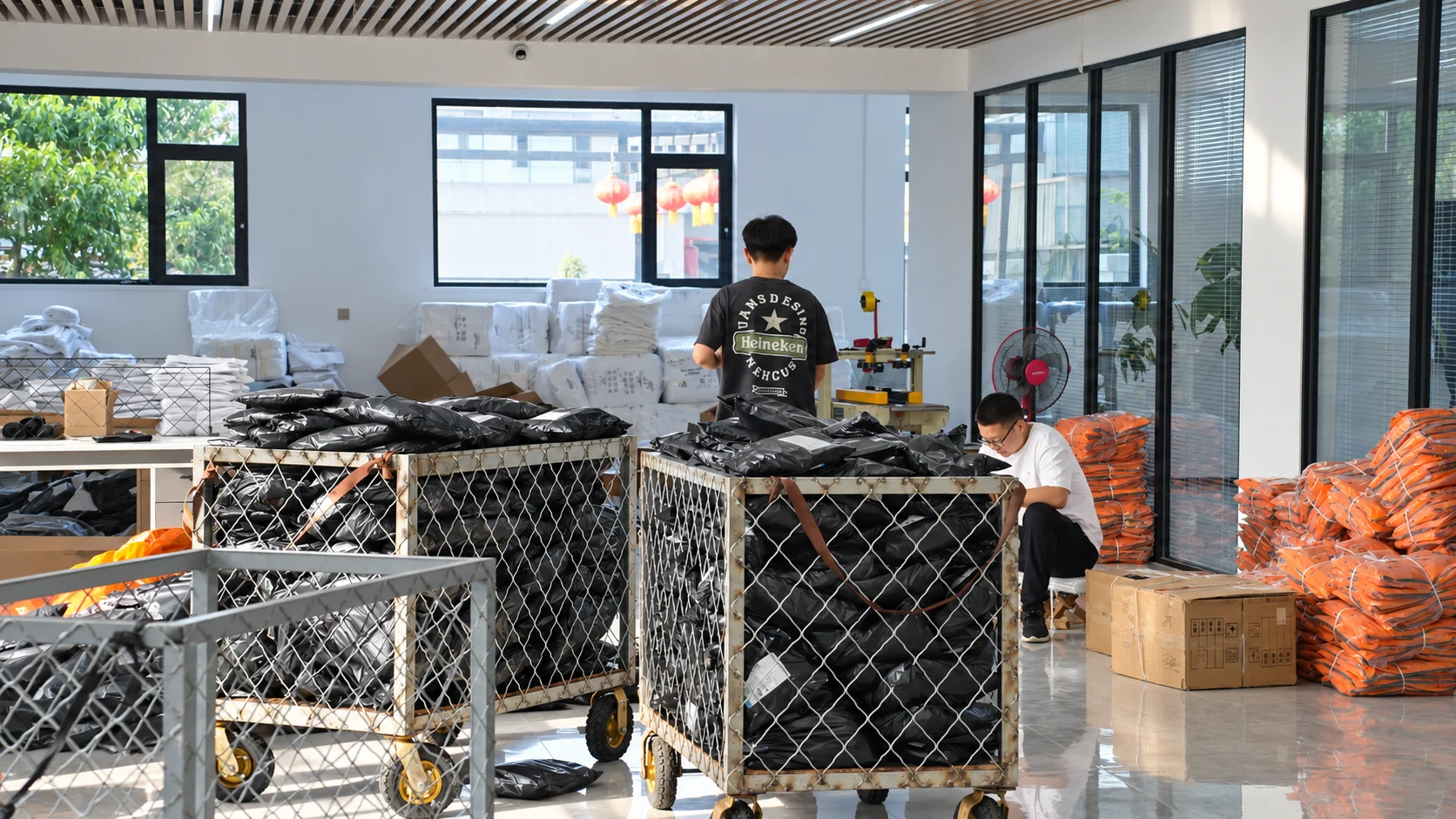 People and bag-filled carts in the factory packing area