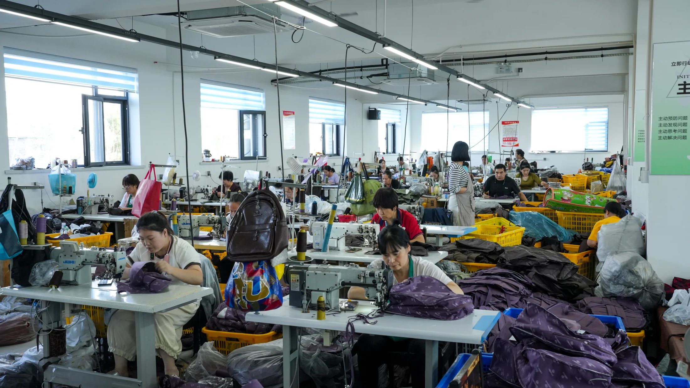 SHANGBAIGE workers sewing bags with purple bag components on the production floor