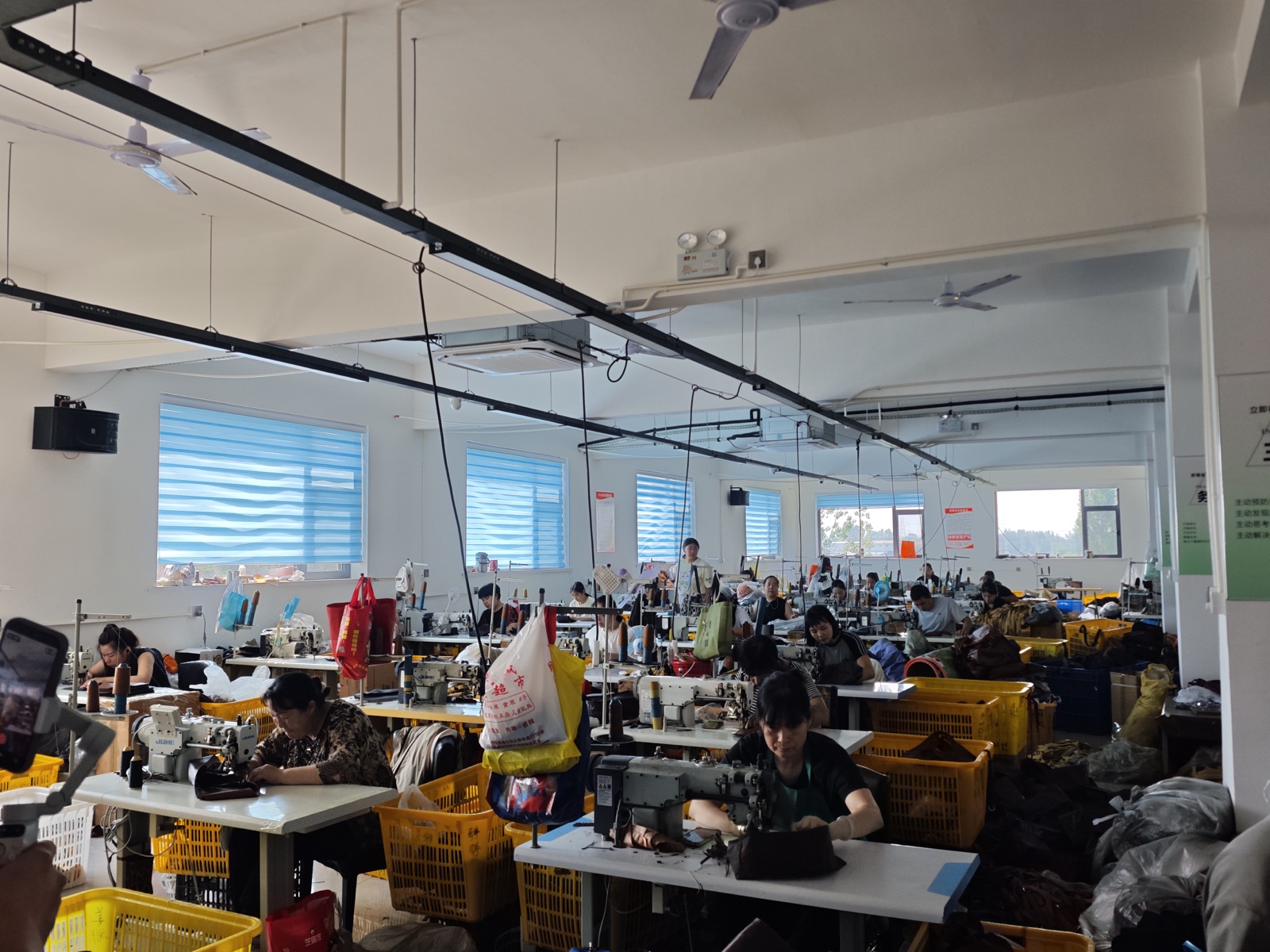 Workers actively sewing bags on the Shangbaige production floor
